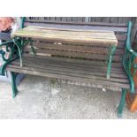 A cast iron garden bench with wooden slats together with a bench.