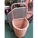 A wicker shopping trolley with a folding table.