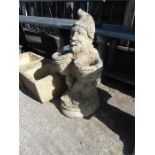 A concrete garden gnome statue.