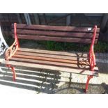 A cast iron garden bench with wooden slats.