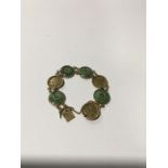 An 18ct gold Chinese Jade disc and character bracelet.