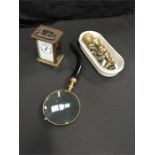 A small brass carriage clock together with a magnifying glass and some weights.
