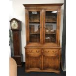 A Georgian style oak dresser with glazed top and two drawers and cupboards under resting on