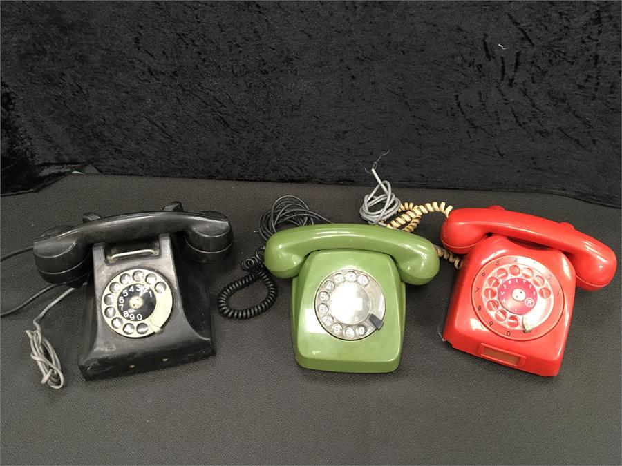 Three vintage rotary telephones.