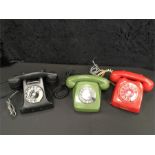 Three vintage rotary telephones.
