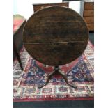 A Georgian oak flip top tripod table resting on pad feet.