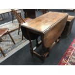 An oak 1930's gateleg table on barley twist legs (3' x 4').