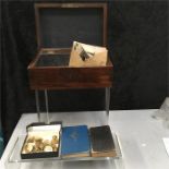 A small box containing black and white photographs with a miniature Bible, a 1973 miniature RAF