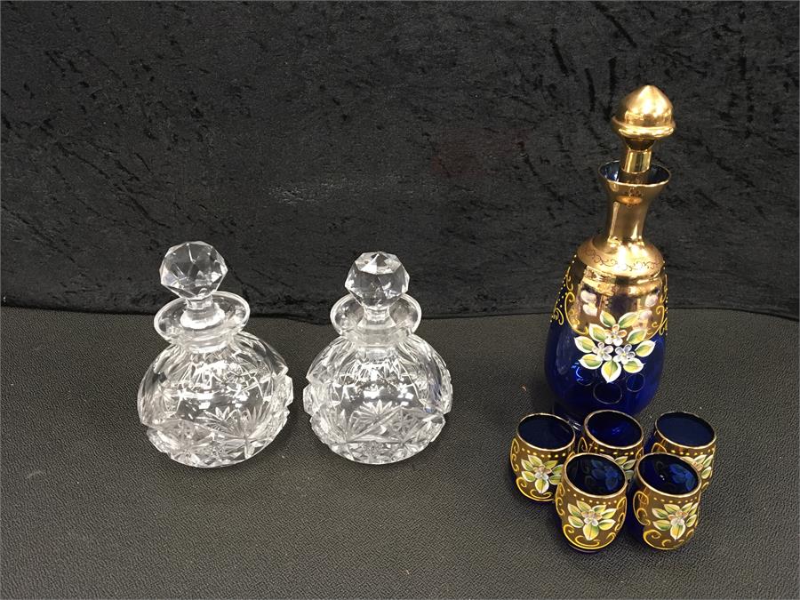 A Bohemian blue decanter with five glasses together two other glass decanters and other various