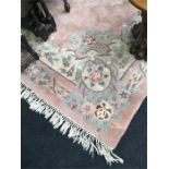 A large Chinese carpet with pink ground and cream and green flower decoration. 9'3" x 12'.