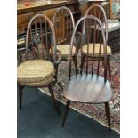 A set of four Ercol Windsor dining chairs with seat pads.