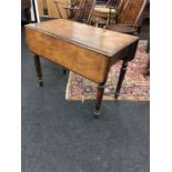 A 18th century mahogany Pembroke table resting on turned supports.