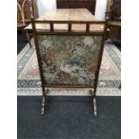 An Edwardian mahogany framed fire screen with a floral woodwork panel insert.