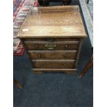 A 19th century oak coal box in the form of a small chest of drawers standing on bracket feet.