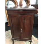 A Lidstone Music Cabinet in mahogany with two doors to front and lift out shelves resting on
