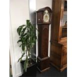 A reproduction grandmother clock with mahogany case and electric movement.