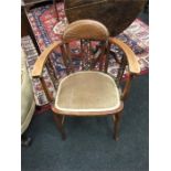 An Edwardian inlaid elbow chair with upholstered seat resting on cabriole legs.
