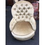 A mid 20th century button back bedroom chair upholstered in gold fabric resting on cabriole legs