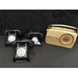 A 1950's Bush radio together with three vintage telephones.