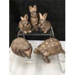 Three Poole Pottery rabbits together with a hedgehog and a tortoise.