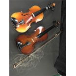 Two violins with bow and cases.