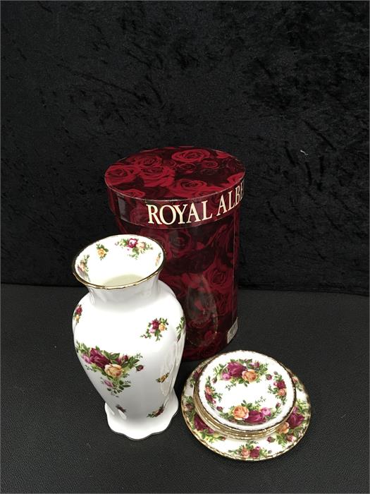 A boxed Royal Albert vase together with four plates.