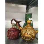 A bronze pint decanter together with a green Dartmouth fish vase and two character pots.