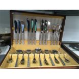 A retro stainless steel cutlery set made by Viners of Sheffield in a wooden canteen.