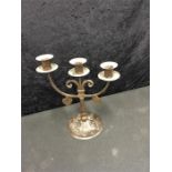 A Goberg hammered metal three branch candlestick with drop heart decoration.