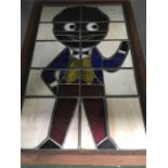 A stained glass framed picture depicting a Golly.