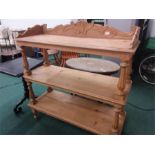 A three tier pine buffet unit resting on columned supports.