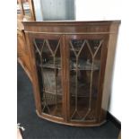 A reproduction bow fronted wall hanging corner cupboard with glazed doors (32" wide x 39" high).