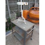 A works trolley on castors with a wind up stool.