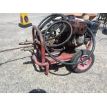 A petrol driven power washer on a wheeled trolley.