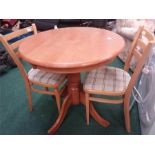 A circular blockwood kitchen table and two chairs.