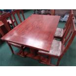 A large dining table with four upholstered chairs.