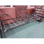 A wrought iron single bed with scrolling to front.