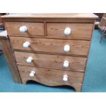 A pine chest of five drawers resting on bracket feet fitted with ceramic handles.