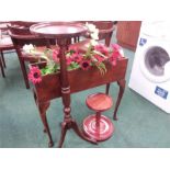 A wooden trough planter with two table stands.