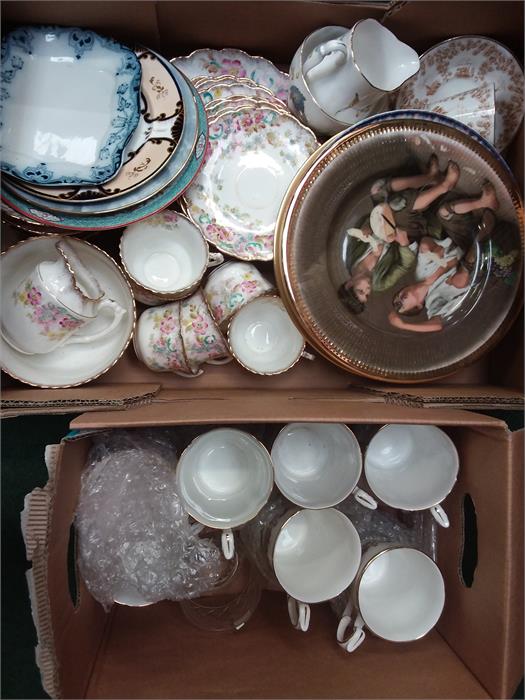 Two boxes containing the residue of various tea sets, plates and glasses.