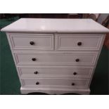 A white painted pine chest of five drawers resting on a plinth base.