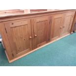 A large pine four cupboard cabinet.