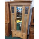 An Art Nouveau style wardrobe with single drawer under.