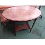 A victorian oval two tier occasional table with galleried rails under, resting on castors.