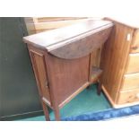 A oak drop-leaf table with cupboard to front.