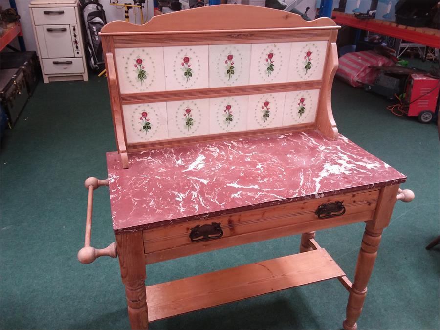 An Edwardian pine washstand fitted with a red marble top and a rose relief tiled splash back .