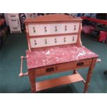 An Edwardian pine washstand fitted with a red marble top and a rose relief tiled splash back .