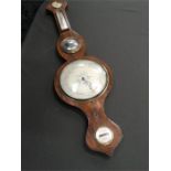 A19th century banjo barometer/thermometer in mahogany case with central concave mirror.