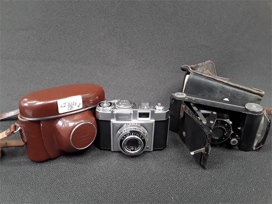 A Vintage Art Deco style Zeiss automatic camera in case together with a Kodak fold out camera also