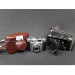 A Vintage Art Deco style Zeiss automatic camera in case together with a Kodak fold out camera also